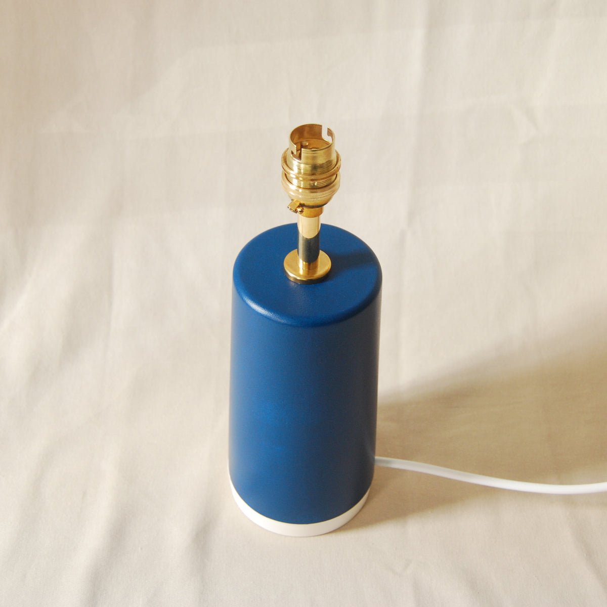 teal blue lamp base with brass fittings viewed from above with neutral background
